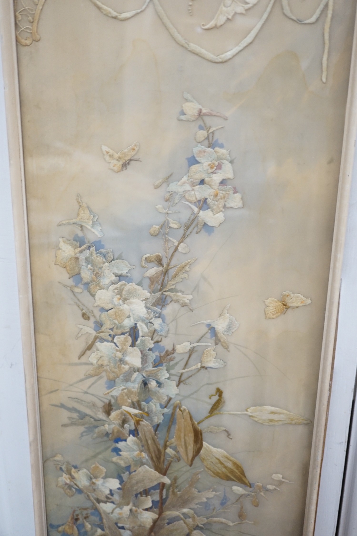 A framed silk embroidered panel, possibly French, cut from a larger piece, 137cms high x 27wide